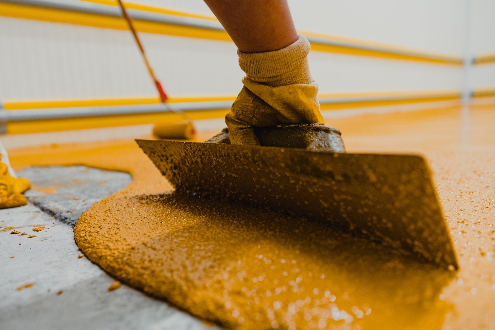 Worker applying epoxy and polyurethane flooring system